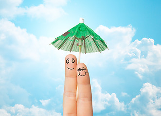 Image showing close up of two fingers with cocktail umbrella