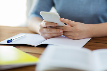 Image showing close up of student with smartphone and notebook