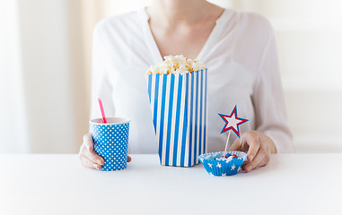 Image showing woman eating popcorn with drink and candies