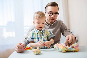 Image showing father and son playing with ball clay at home