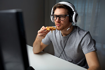 Image showing man in headset playing computer video game at home