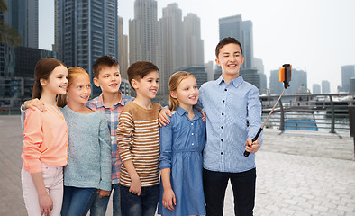 Image showing happy children with smartphone and selfie stick