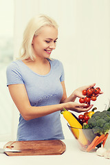 Image showing smiling young woman cooking vegetables at home