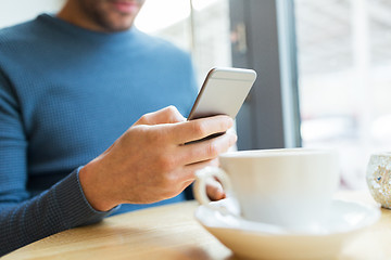 Image showing close up of man with smartphones at cafe