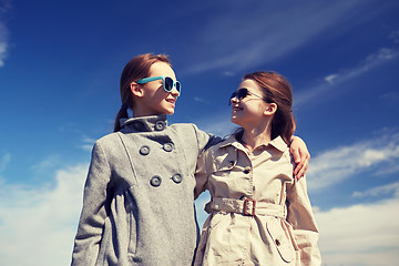 Image showing happy little girls hugging and talking outdoors