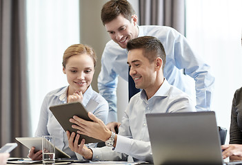 Image showing smiling business people with tablet pc in office