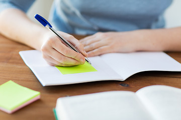 Image showing close up of student with book and notebook at home