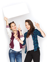 Image showing smiling teenage girls holding white blank board