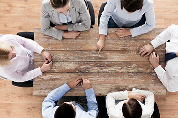 Image showing close up of business team sitting at table