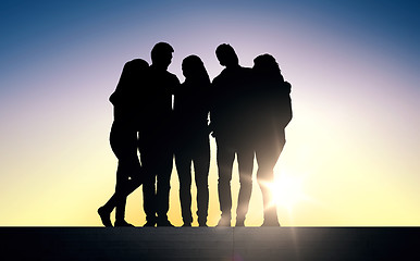 Image showing silhouettes of friends sitting on stairs over sun