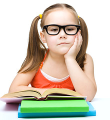 Image showing Little girl is reading a book