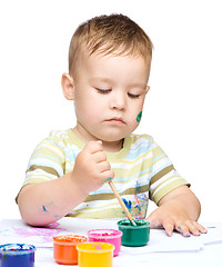 Image showing Little boy is playing with paints