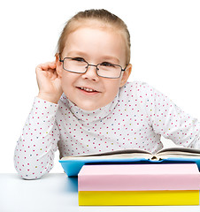 Image showing Little girl is reading a book