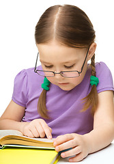 Image showing Little girl is reading a book