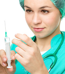 Image showing Young nurse is preparing syringe for injection