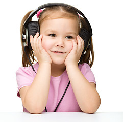 Image showing Little girl is enjoying music using headphones