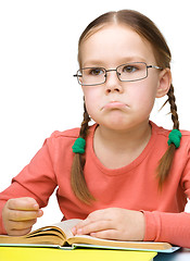 Image showing Little girl is reading a book