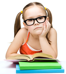 Image showing Little girl is reading a book