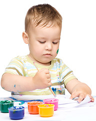 Image showing Little boy is playing with paints