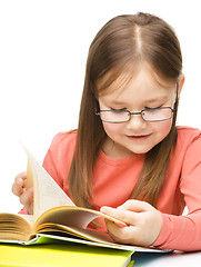 Image showing Little girl is reading a book