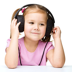 Image showing Little girl is enjoying music using headphones