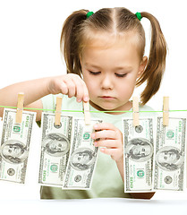 Image showing Cute little girl is playing with paper money