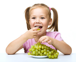 Image showing Little girl is eating grapes