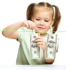 Image showing Cute little girl is playing with paper money