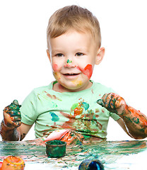 Image showing Little boy is playing with paints