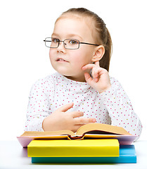 Image showing Little girl is reading a book