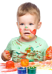 Image showing Little boy is playing with paints