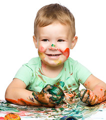 Image showing Little boy is playing with paints