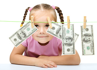 Image showing Cute little girl is playing with paper money