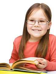 Image showing Little girl is reading a book