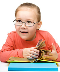 Image showing Little girl is reading a book