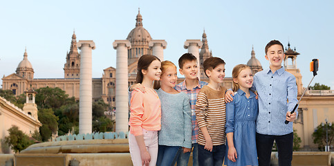 Image showing happy children with smartphone and selfie stick