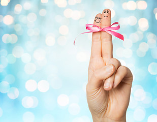 Image showing close up of two fingers tied by pink bow knot