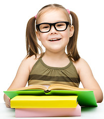 Image showing Little girl is reading a book