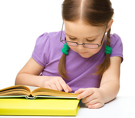 Image showing Little girl is reading a book