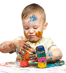 Image showing Portrait of a cute little boy playing with paints