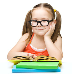 Image showing Little girl is reading a book