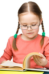 Image showing Little girl is reading a book