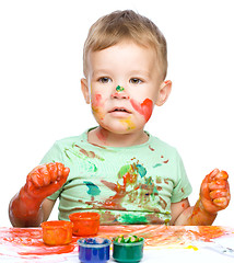 Image showing Little boy is playing with paints