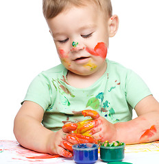 Image showing Little boy is playing with paints