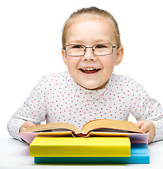 Image showing Little girl is reading a book