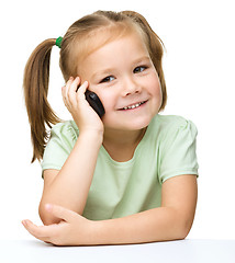 Image showing Cute little girl is talking on a cell phone