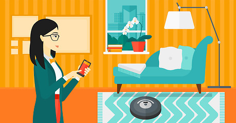 Image showing Woman with robot vacuum cleaner.