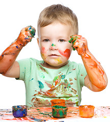 Image showing Little boy is playing with paints