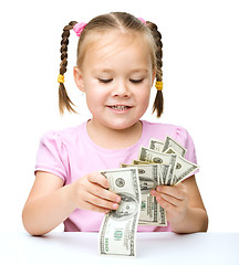 Image showing Little girl is counting dollars