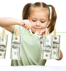 Image showing Cute little girl is playing with paper money